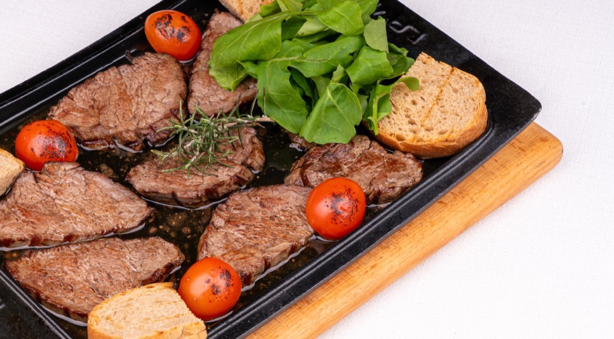 Nuz Restaurant - beef fillet in clarified butter on a hot cast-iron dish with arugula and toasted bread